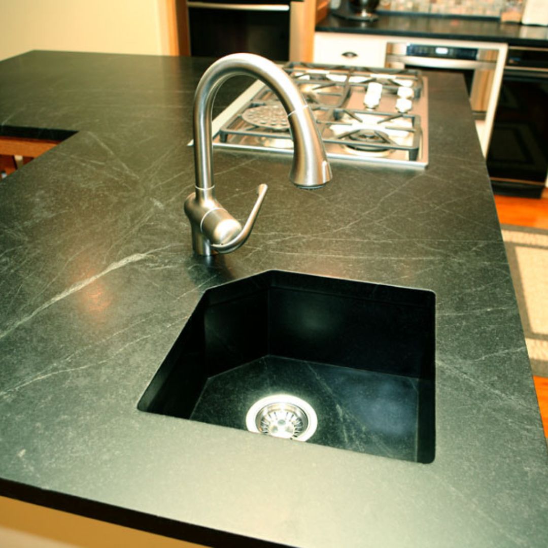 kitchen sink area with soapstone countertops